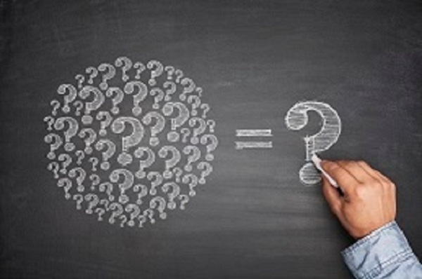 A chalkboard with many question marks drawn into a circle shape, then an 